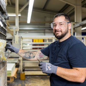 Young man working on machine and smiling into the camera